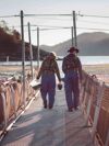 Two employees walking down the gangaway between pens at a seasite