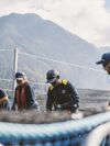 Four farm employees securing net