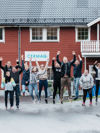 Bilde av ansatte som hopper foran kontorbygget i Nordfold i Steigen